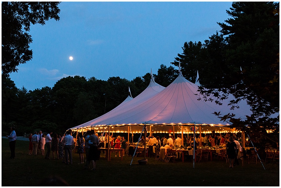 white tent wedding reception at dusk under a full moon 