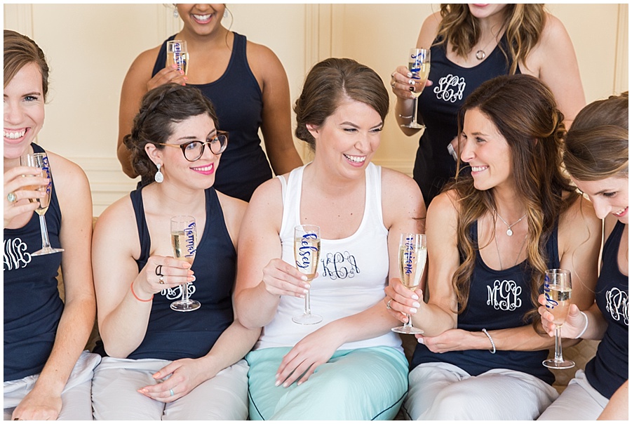 Bridesmaids with monogrammed shirts and glasses cheers the bride