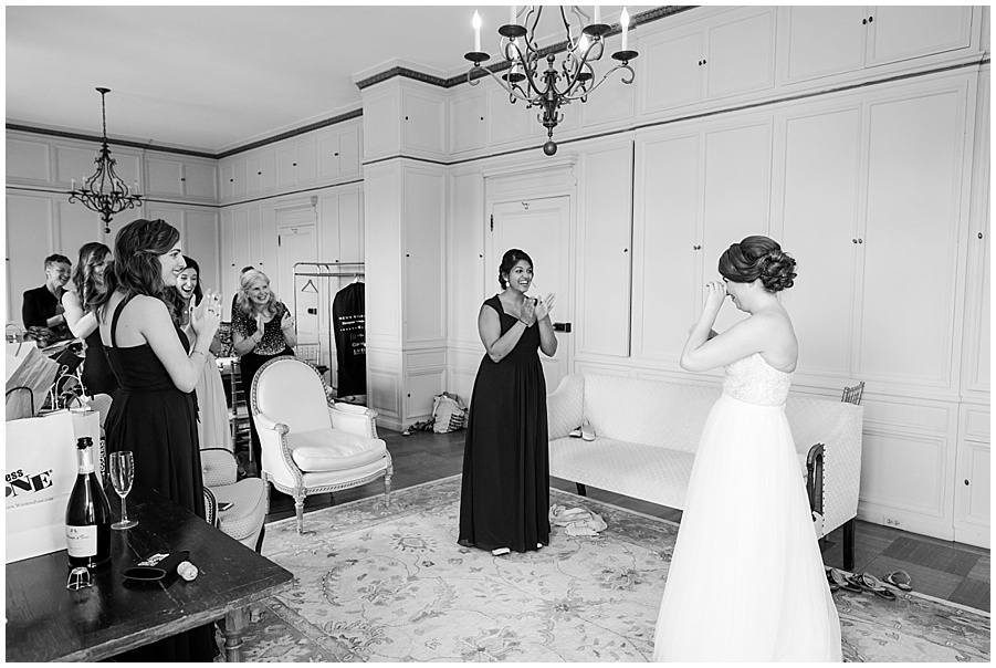 bride and bridesmaids tear up as she puts on dress