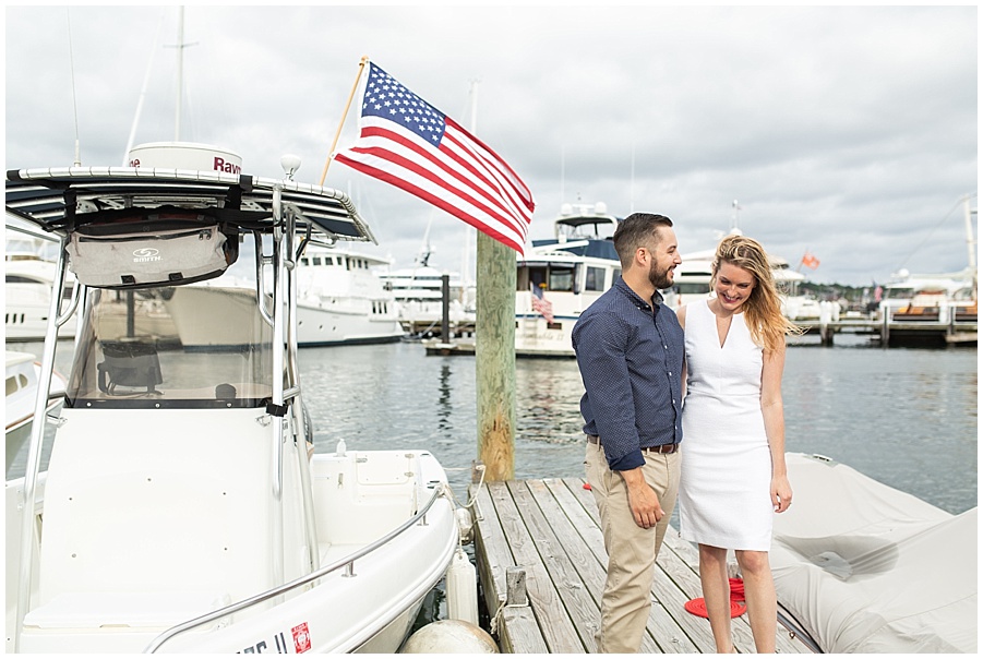 american flag with boat and engaged couple on docks 