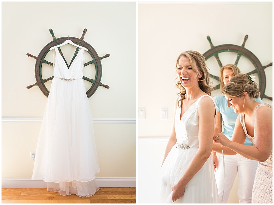 bride puts on her wedding dress with help from mom and sister