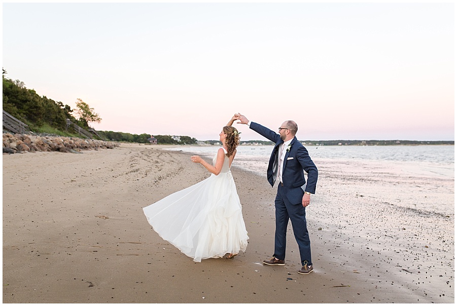 bride and groom do a twirl on the beach in wellfleet, ma