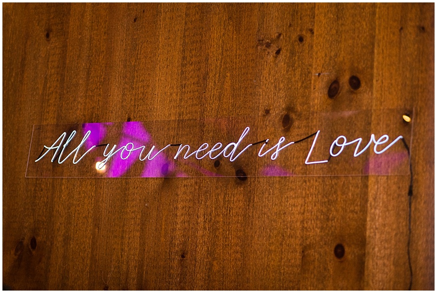 All you need is love neon sign at wedding reception 