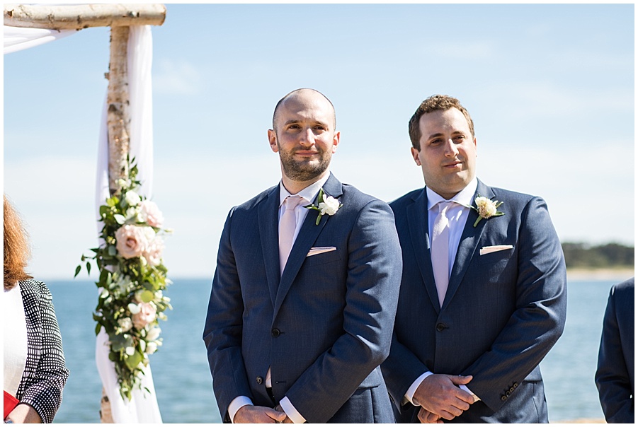 groom watches his bride walk down the aisle at cape cod wedding