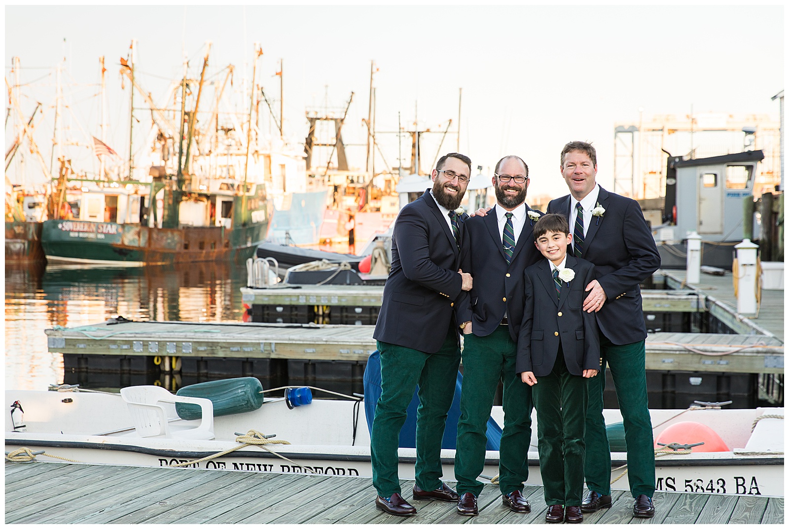 Groomsmen pose near the fishing boats in New Bedford harbor
