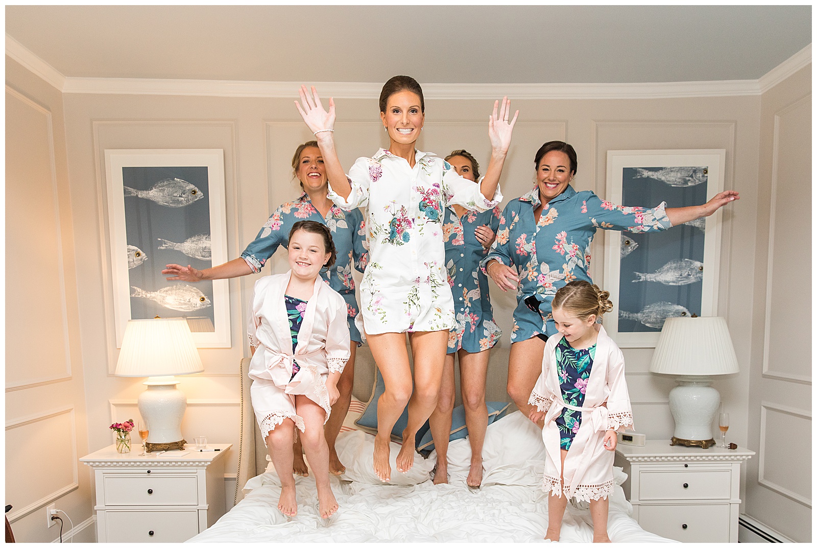 bridal party bounces on the bed at bayberry inn for photos