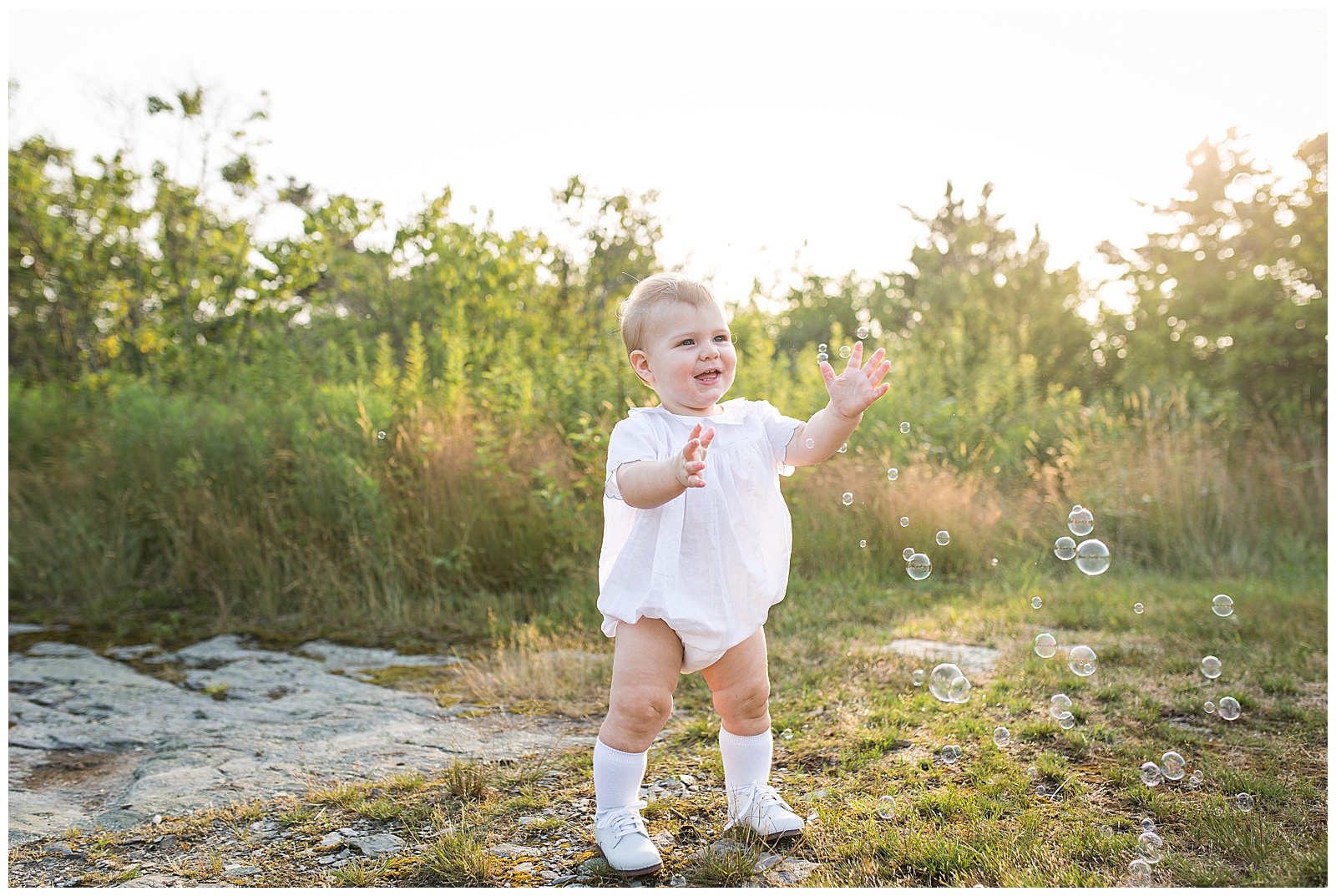 little boy catching bubbles at his family photo session