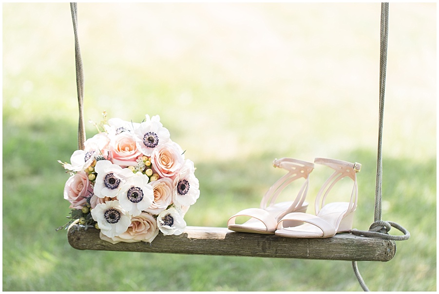 Wedding bouquet and shoes on tree swing