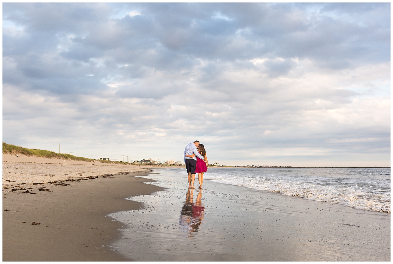 couple walks down the beach at their engagement session 