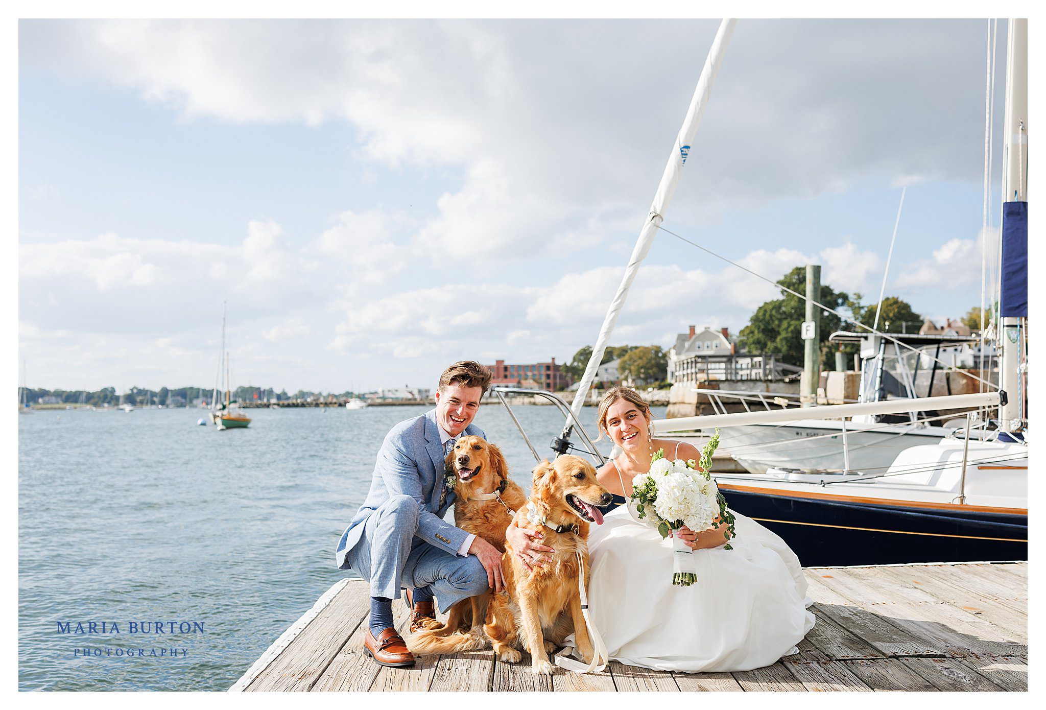 bride and groom pose with two golden retrievers